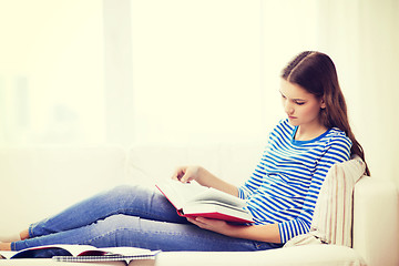 Image showing calm teenage girl reading book on couch