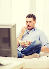 Image showing smiling man watching sports at home