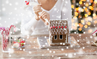 Image showing close up of woman making gingerbread house at home