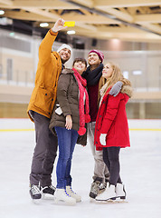 Image showing happy friends taking selfie on skating rink