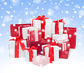 Image showing christmas presents over blue background with snow