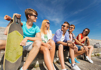 Image showing group of smiling friends sitting on city street