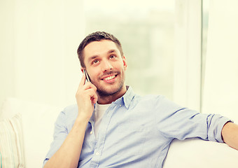 Image showing smiling man with smartphone at home