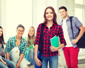 Image showing smiling female student with bag and notebooks