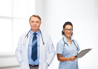 Image showing smiling doctors with clipboard and stethoscopes