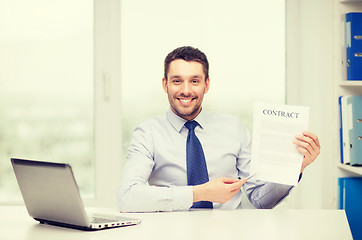 Image showing businessman with laptop and contract at office