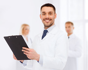 Image showing smiling male doctor with clipboard