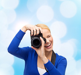 Image showing smiling woman taking picture with digital camera