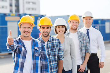 Image showing group of smiling builders in hardhats outdoors