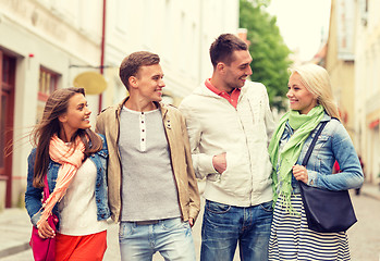 Image showing group of smiling friends walking in the city