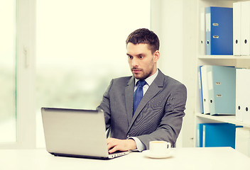 Image showing busy businessman with laptop and coffee