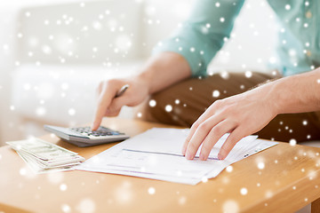 Image showing close up of man counting money and making notes