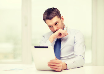 Image showing stressed businessman with tablet pc and documents