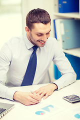 Image showing smiling businessman with laptop and documents