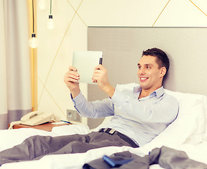 Image showing happy businesswoman with tablet pc in hotel room