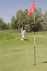 Image showing Female golfer playing golf