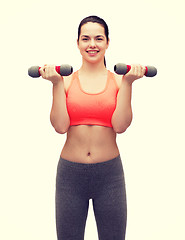 Image showing young sporty woman with light dumbbells