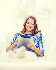 Image showing smiling teenage girl with tablet pc at home