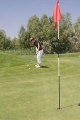 Image showing Female golfer playing golf