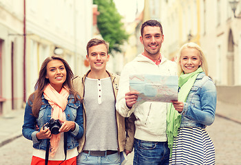 Image showing group of smiling friends with map and photocamera