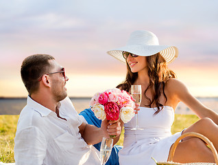 Image showing smiling couple drinking champagne on picnic