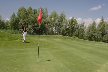 Image showing Female golfer playing golf