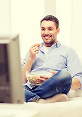 Image showing smiling man watching sports at home