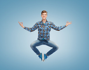 Image showing smiling young man jumping in air
