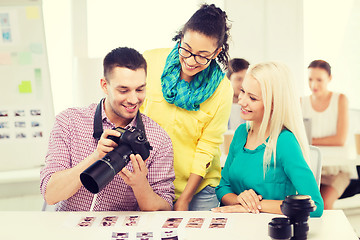 Image showing smiling team with photocamera working in office