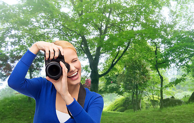 Image showing smiling woman taking picture with digital camera