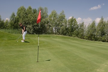 Image showing Female golfer playing golf