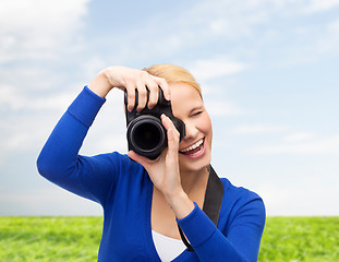 Image showing smiling woman taking picture with digital camera