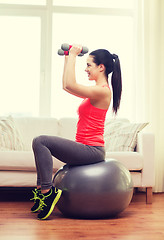 Image showing smiling girl exercising with fitness ball