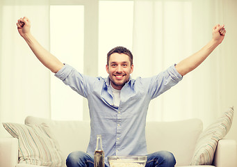 Image showing smiling man watching sports at home