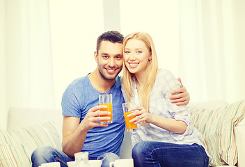 Image showing smiling happy couple at home drinking juice