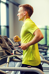 Image showing smiling man exercising on treadmill in gym
