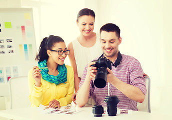 Image showing smiling team with photocamera working in office