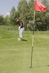 Image showing Female golfer playing golf