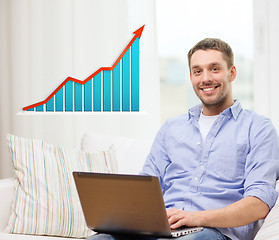 Image showing smiling man with laptop and growth chart at home