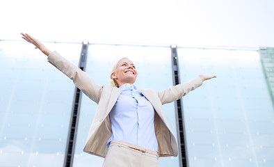 Image showing young smiling businesswoman over office building