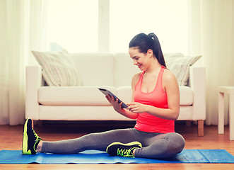 Image showing smiling teenage girl streching on floor at home