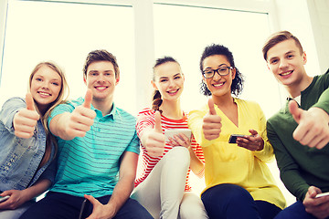 Image showing smiling students with smartphone texting at school