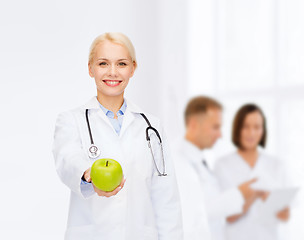 Image showing smiling female doctor with green apple