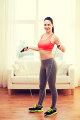 Image showing smiling teenage girl with skipping rope at home
