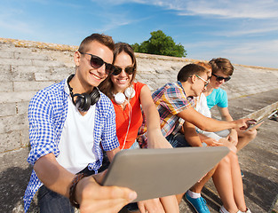 Image showing group of smiling friends with tablet pc outdoors