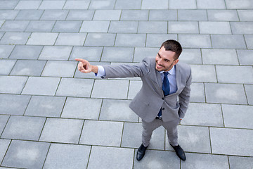 Image showing young smiling businessman outdoors from top