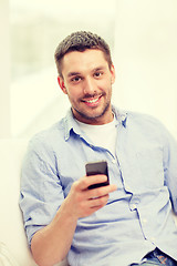 Image showing smiling man with smartphone at home