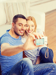 Image showing smiling couple taking picture with digital camera
