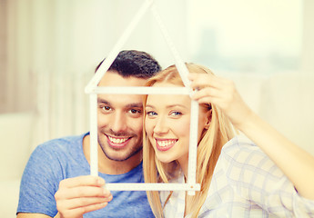 Image showing smiling couple with house from measuring tape