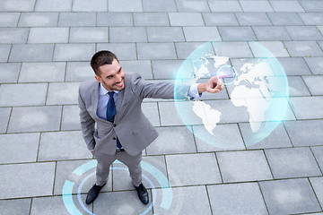 Image showing smiling businessman with globe projection outdoors